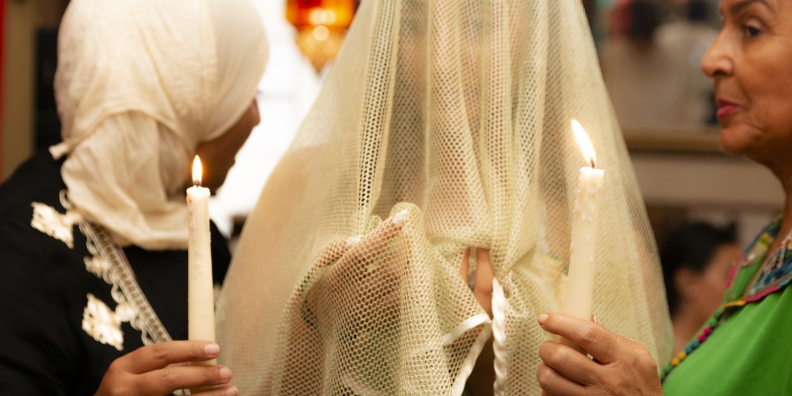 3 vrouwen, 2 houden een kaars vast, de derde is gesluierd 3 vrouwen, 2 houden een kaars vast, de derde is gesluierd